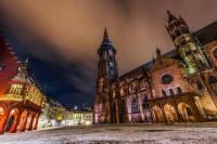 Das Freiburger Münster mit dem historischen Kaufhaus bei Nacht